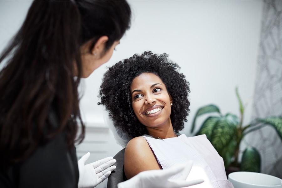 Curly haired woman at the dentist in the dental chair smiles after finding the best dentist in Canton, GA